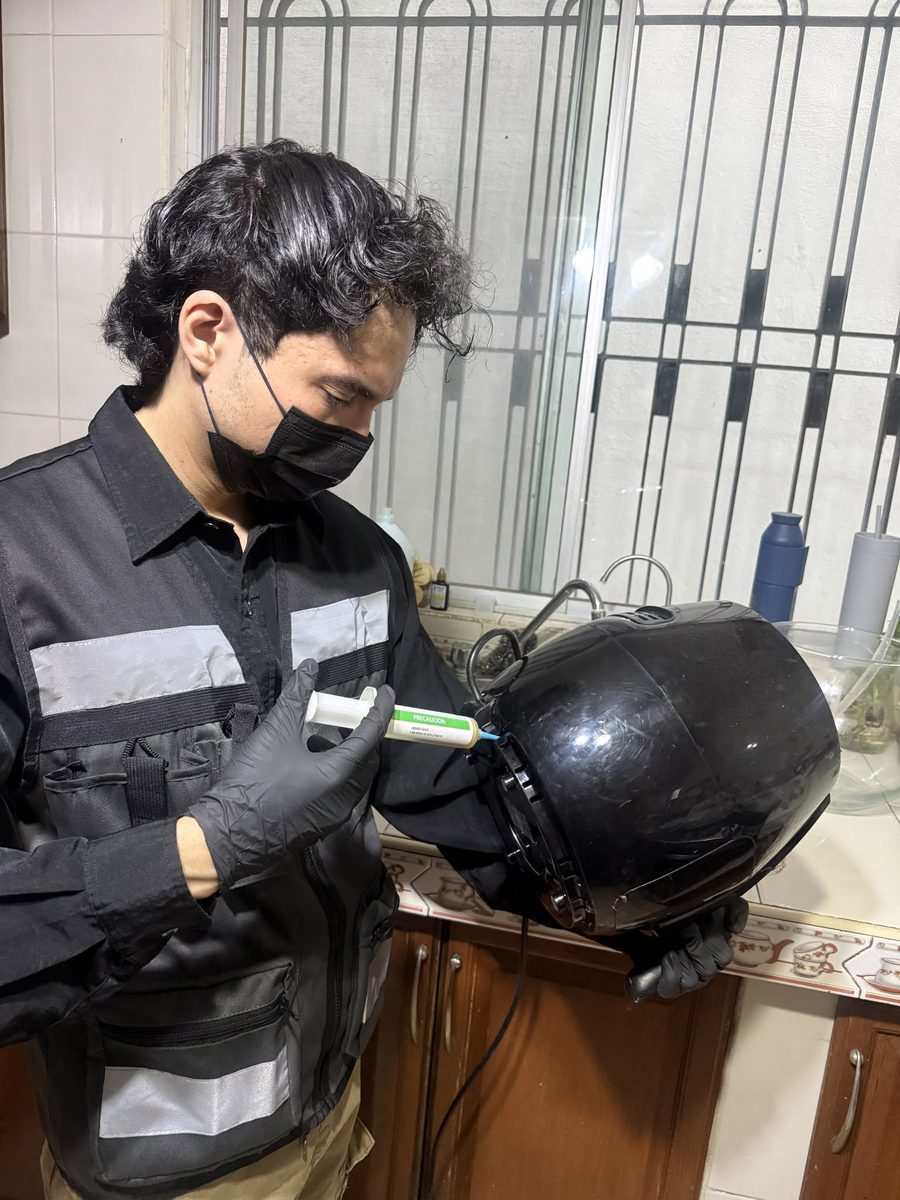 Técnico de FUMITECT aplicando gel dentro de un electrodoméstico de cocina