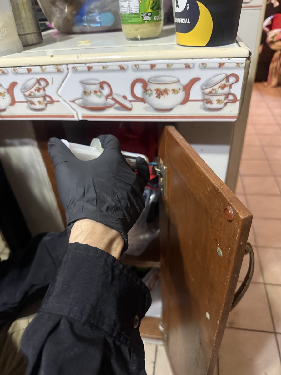 Técnico de FUMITECT aplicando tratamiento dentro de un gabinete de cocina
